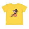 Baby Witch sitting on a pumpkin on a shirt in the color Yellow - Memento Mary