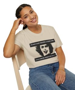 'It's not easy having a good time...even smiling makes my face ache' on a shirt in the color Sand. - Memento Mary